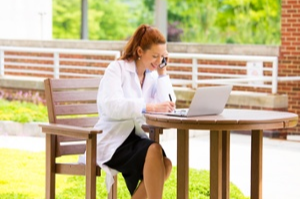 Closeup portrait, young smiling confident female doctor, healthcare professional talking on phone, giving consultation isolated background hospital park- Patient visit health care- Positive emotions-3