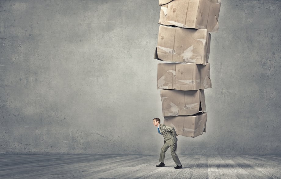 Young businessman in suit carrying big stack of carton boxes.jpeg