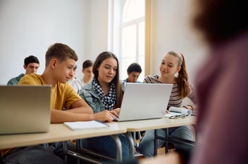 high school students working on a laptop