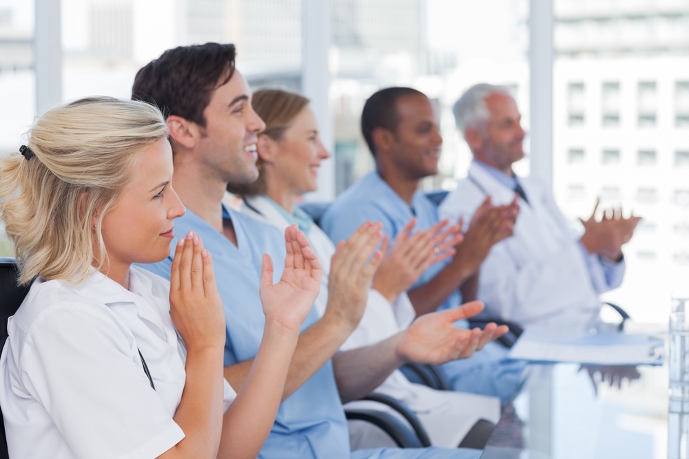 Medical team clapping hands during a conference